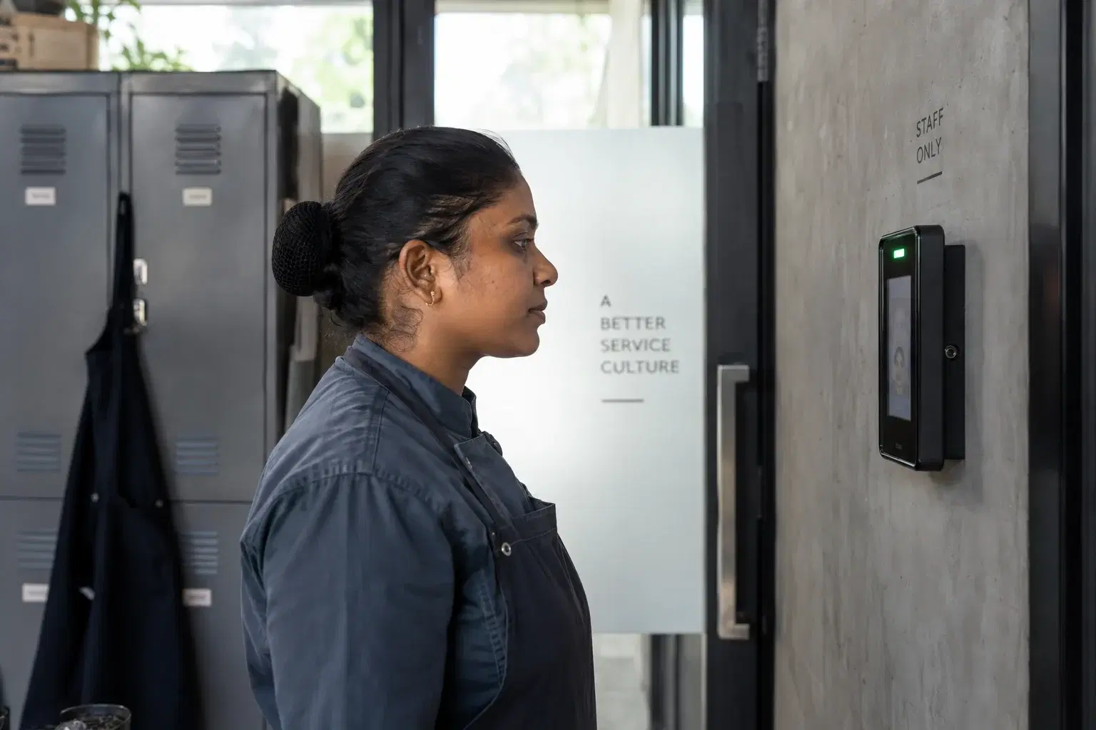 Kitchen employee facing an attendance terminal at the staff entrance